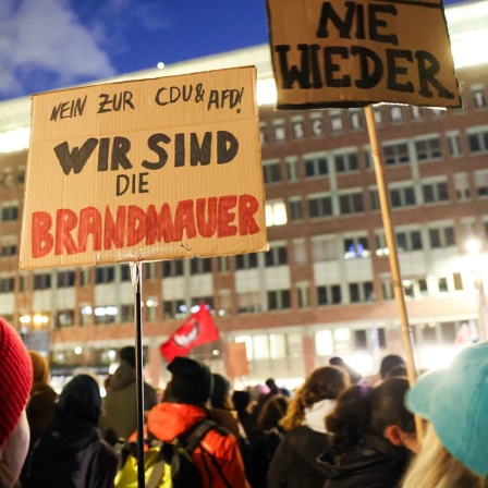 Teilnehmende einer Protestaktion demonstrieren unter dem Motto "Merz und AfD stoppen - Asylrecht verteidigen" vor der Geschäftsstelle der AfD Hamburg.