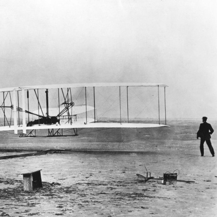 Schwarzweißfotografie des ersten Flugzeugs der Wright-Brüder.