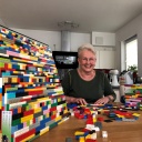 Die Lego-Oma Rita Ebel aus Hanau sitzt in ihrer Küche, neben ihr eine Rollstuhlrampen aus Legosteinen. 