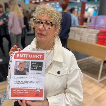 Lizzie Doronauf der Frankfurter Buchmesse mit einem roten Vermissten-Plakat © Nadine Kreuzahler