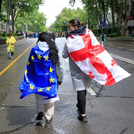 Zwei Menschen mit georgischer National- und EU-Flagge während eines Protestes der Opposition gegen das "russische Gesetz" in Tbilissi (13.05.2024)