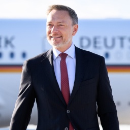 Finanzminister Christian Lindner steht auf dem Flughafen Berlin Brandenburg vor einem Regierungsflugzeug.