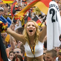 Deutsche Fußballfans mit Deutschlandfahnen jubeln auf der Fan-Meile Berlin anlässlich des Spiels Deutschland:Argentinien der FIFA Fussball Weltmeisterschaft 2006.