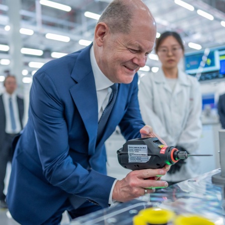 Bundeskanzler Olaf Scholz (SPD), besucht die Firma Bosch mit der Produktionsstätte von Wasserstoffantrieben in Chongqing in China und schraubt mit einem Akkuschrauber in der Fertigung.
