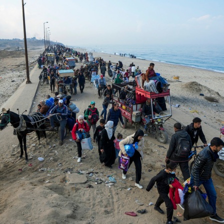 Vertriebene Palästinenser gehen auf einer Straße im Zentrum des Gazastreifens.