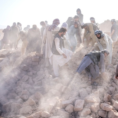 Freiwillige arbeitet in den Trümmern nach einem Erdbeben in Afghanistan.