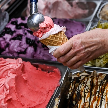 Eine Kugel Eis wird in einer Berliner Eisdiele in eine Waffel gesetzt
