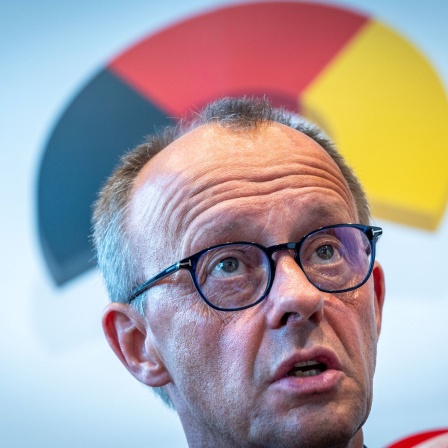 CDU-Chef Friedrich Merz, über seinem Kopf -bogenförmig- die Deutschlandfarben Scwharz, Rot und Gold