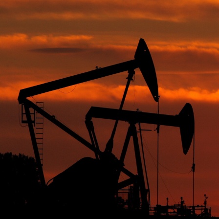 Ölpumpen stehen im Sonnenuntergang auf einem Ölfeld