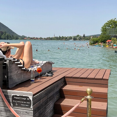 Ein Pärchen blickt vom Ufer auf einen Badesee.