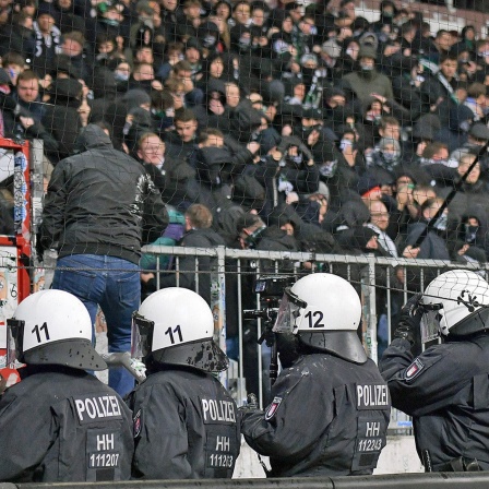 Polizisten stehen vor dem Block von Hannover 96 im Millerntor-Stadion