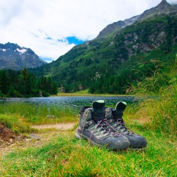 Wanderschuhe, fotografiert vor einem See in den Bergen.