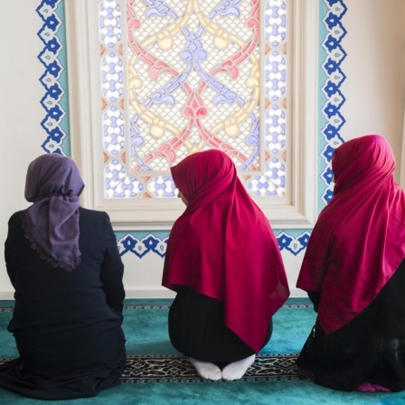 Drei junge Frauen beten in der Sehitlik Moschee in Berlin Neukölln, 2017.