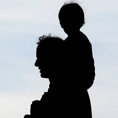 Ein Mann trägt ein Kleinkind auf seinen Schultern