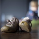 Einer von zwei Kinderschuhen im Bild hat ein Loch im vorderen Bereich.