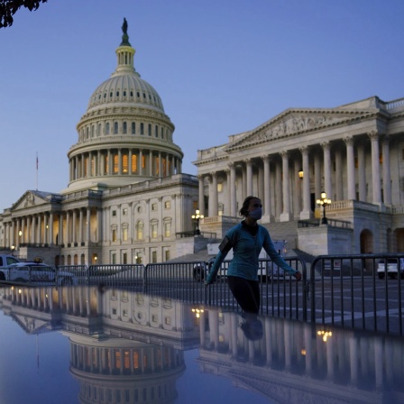 Eine Frau joggt abends am Kapitol in Washington (USA) vorbei.