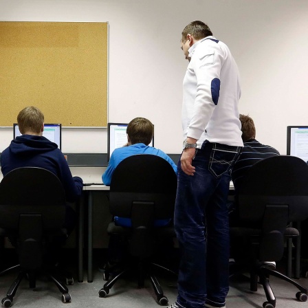 Ein Lehrer gibt Informatik-Unterricht.