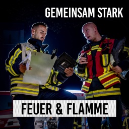 Zwei Feuerwehrleute beraten sich bei Nacht