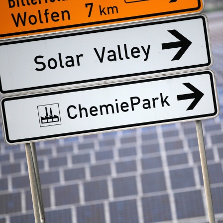 Ein Schild weist an einer Straße vor einem Solarpark zum «Solar Valley» in Bitterfeld-Wolfen