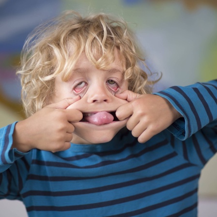 Porträt von einem 6 Jahre alten Jungen, der eine Grimasse macht.