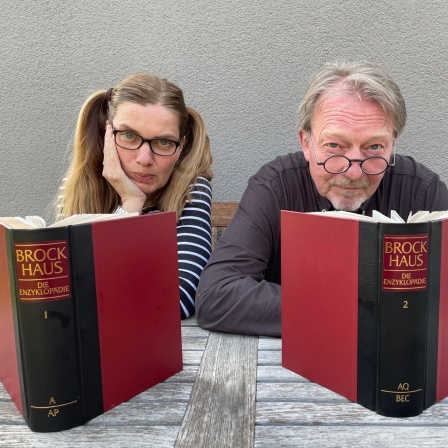Dietmar Wischmeyer und Tina Voß sitzen mit Büchern am Tisch