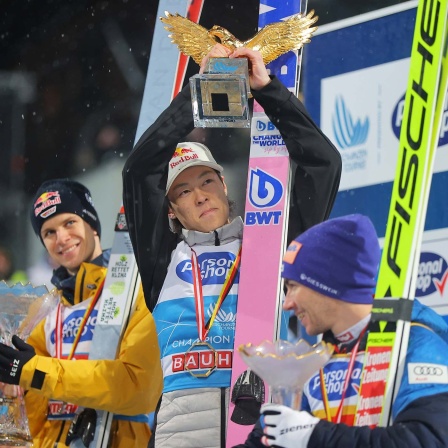 Ryoyu Kobayashi reckt bei der Siegerehrung der Vierschanzentournee den goldenen Adler in die Höhe, neben ihm ist der Zweitplatzierte Andreas Wellinger.