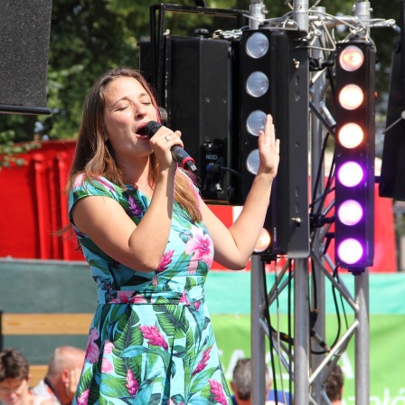 Eine Frau singt auf einer Bühne