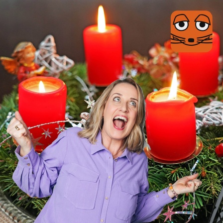 Verena singt vor Adventskranz mit vier Kerzen