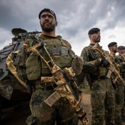 Soldaten der Bundeswehr in Uniform und mit Waffen in der Hand stehen beim Besuch von Kanzler Scholz im Camp Adrian Rohn. Bundeskanzler Scholz (SPD) hat Litauen zusätzliche militärische Unterstützung zugesagt.