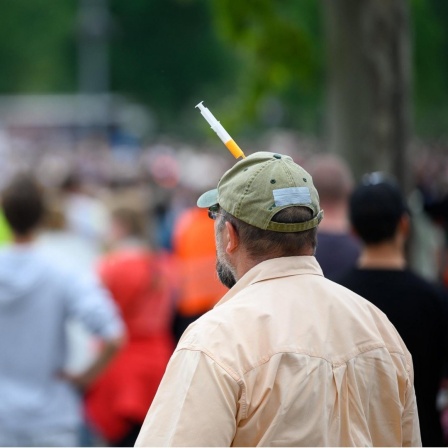 Ein Impfgegner bei einer Demonstration gegen die Corona-Schutzmaßnahmen am 9.05.2020 in Stuttgart. An seine Mütze hat er vorne eine Spritze gesteckt.