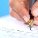 Frauenhand mit Füller schreibt einen Brief Symbolfoto