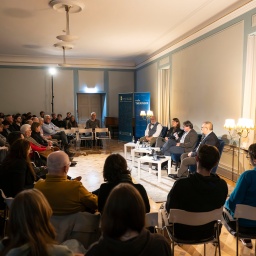 Menschen sitzen in einem Saal zusammen