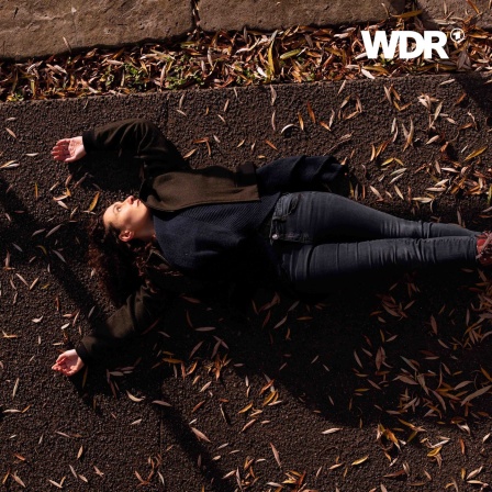 Raquel Meseguer Zafe liegt auf dem Boden einer herbstlichen Straße.