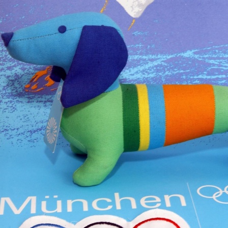 Dackel "Waldi", das offizielle Maskottchen der Olympischen Sommerspiele 1972 in München, als Stofftier auf einem Olympiaplakat.
