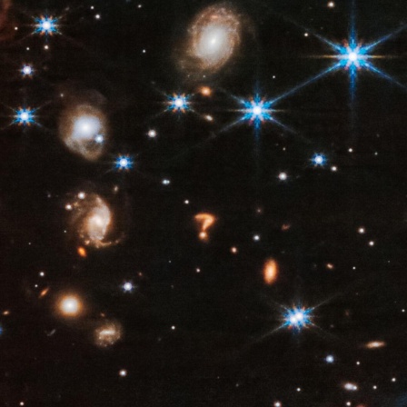 Eine Detailaufnahme des Sternenhimmels zeigt viele bunte Himmelsobjekte - darunter auch eine Konstellation, die verblüffend wie ein Fragezeichen aussieht.