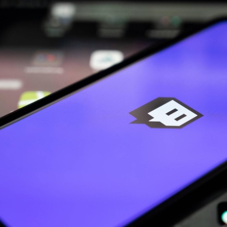 Blick auf ein Handy, auf dem Bildschirm ist das Twitch-Logo der App zu sehen