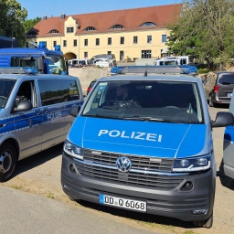 Polizeifahrzeuge stehen vor einem Gebäude, das bei der Razzia gegen das so genannte &#034;Königreich Deutschland&#034; durchsucht wird.
