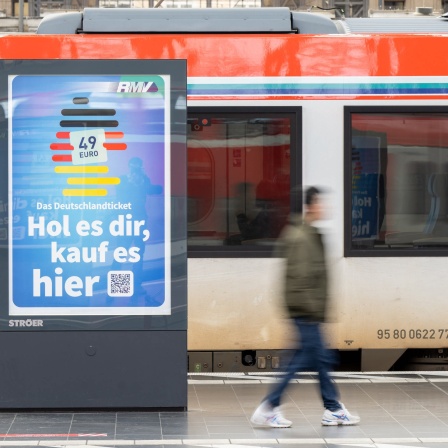 Die Werbung für das Deutschlandticket ist an einem Bahnsteig vor einer Bahn des ÖPNV zu sehen.