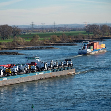 Frachtschiff auf dem Rhein bei Krefeld: Flüsse wie der Rhein fließen auch in der Ebene schnell. Der Grund ist der geringe Reibungswiderstand im Wasser. Und je weiter weg vom Ufer und je tiefer das Flussbett, desto schneller fließt das Wasser.