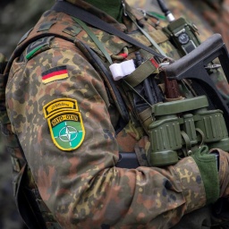 Soldaten der deutschen Bundeswehr und NATO Emblem an der Kleidung, in voller Ausrüstung.