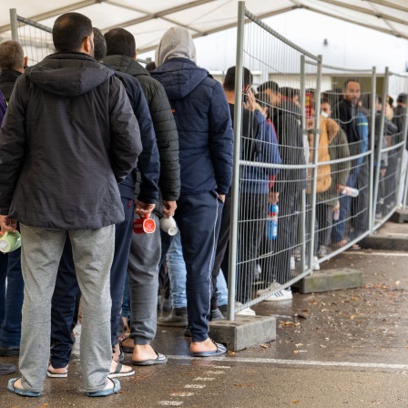 In der Landeserstaufnahmestelle (LEA) warten Flüchtlinge in einer Schlange vor der Essensausgabe.