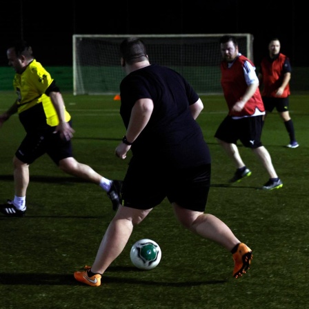 Mehrere Männer laufen beim Fußballtraining über den Platz.