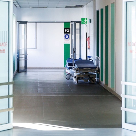 Krankenbetten stehen in einem Gang im Klinikum