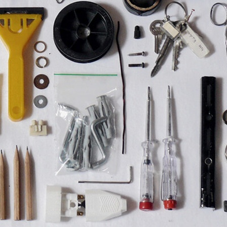 Blick auf Werkzeuge, die nebeneinander liegen. Seil, Schraubenzieher, Dübel, Schere und anderes.