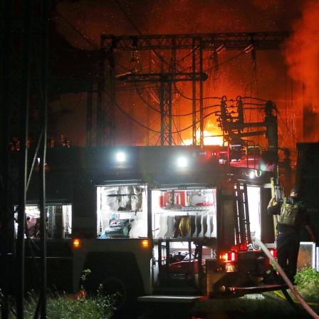 Feuer in einem Elektrizitätswerk, im Vordergrund ein Feuerwehrfahrzeug