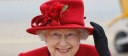 Queen Elizabeth II holds on to her hat in high winds during a visit to RAF Valley
