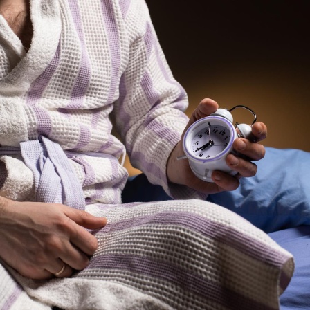 Stilisiertes Foto eines Mannes im Bademantel, der eine Uhr in der Hand hält