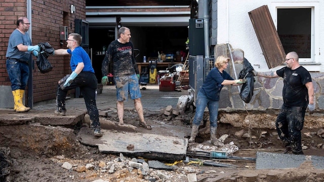 Menschen im Ortsteil Arloff räumen ein durch das Unwetter beschädigtes Haus aus.