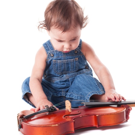 Ein Baby spielt mit einer Violine
