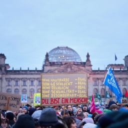 "Du. Bist. Ein. Mensch!" steht auf einem Plakat während der Demonstration "Aufstand der Anständigen – Demo für die Brandmauer" vor dem Reichstag, 02.02.2025; © picture alliance/dpa/Annette Riedl